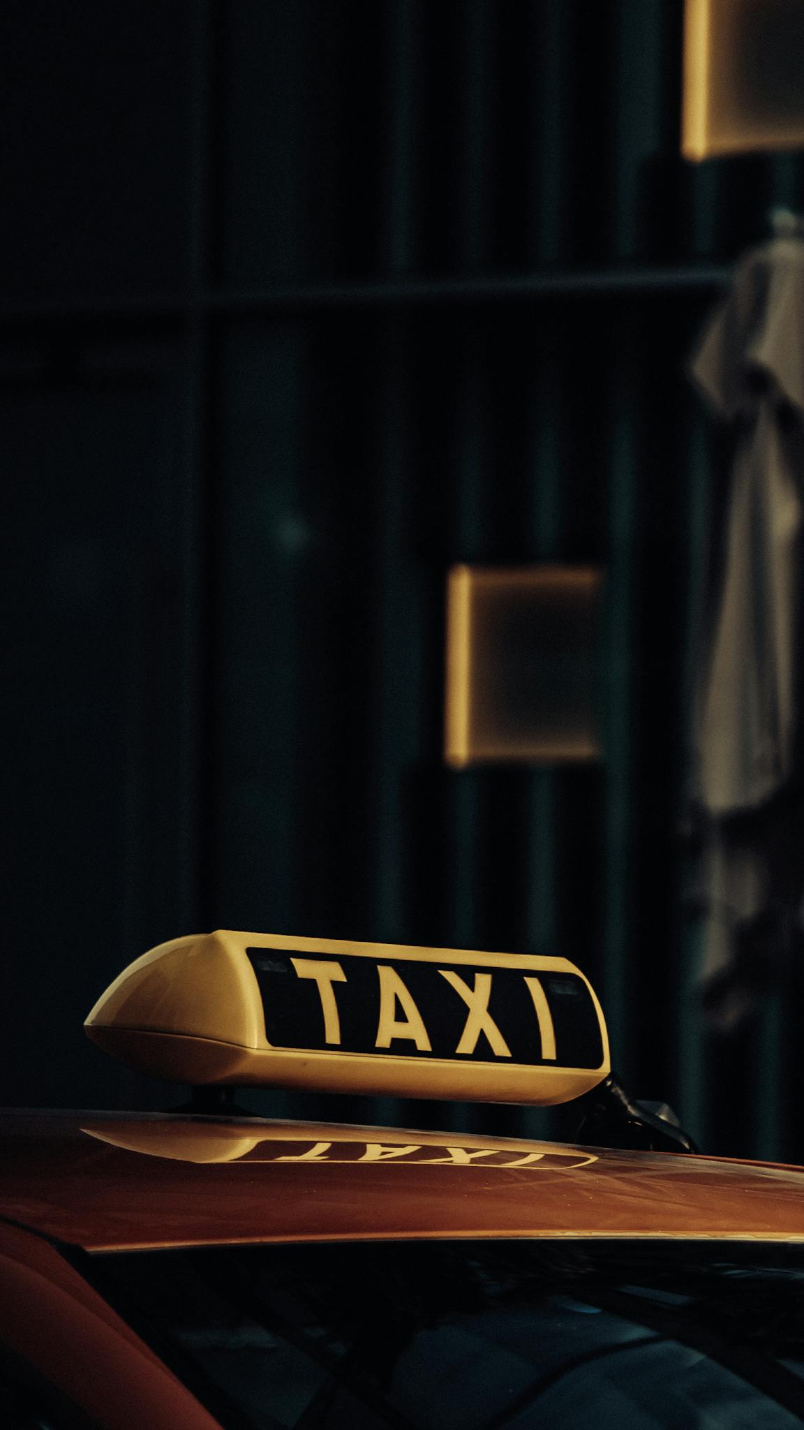 Close-up of a taxi under dim lights in Dubai, highlighting the urban atmosphere.
